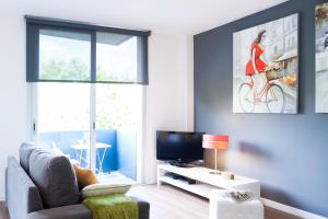 a living room with a couch and a tv at Feelathome Poblenou Beach Apartments in Barcelona