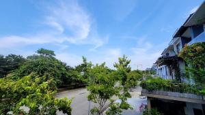 an empty street with trees and a building at Hue House Stay in Thôn Trường Giang