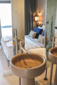 a bathroom with a sink and a bed and a mirror at Naxos Rhyton in Naxos Chora