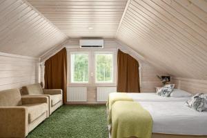 ein Schlafzimmer mit zwei Betten und einer Couch und einem Fenster in der Unterkunft Lehmonkärki Resort in Asikkala