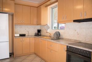- une cuisine avec des placards en bois et un comptoir dans l'établissement Gtrip Ellinikon Experience Apartment - 31506, à Athènes