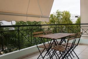 アテネにあるGtrip Ellinikon Experience Apartment - 31506の木製テーブルと椅子付きのバルコニー