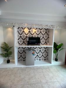 a living room with a tv and a wall at Petunya Phuket Guest House in Ban Huai Luk (1)