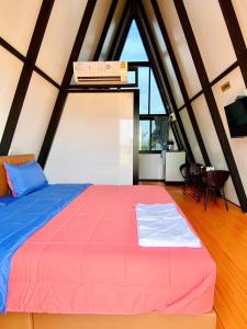 un grande letto in una stanza con una grande finestra di Sean Sawat Resort 2 
