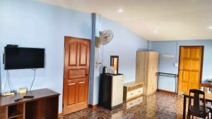 een woonkamer met een koelkast en een televisie bij Baan Asree บ้านอัสรี in Ao Nang Beach