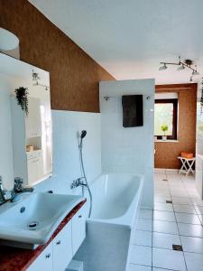 W łazience znajduje się biała wanna i umywalka. w obiekcie Idyllische Stadtrand-FeWo w Lipsku