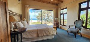 ein Schlafzimmer mit einem Bett und einem Tisch und einem Fenster in der Unterkunft Monkey Valley Resort in Noordhoek + 56 Fotos