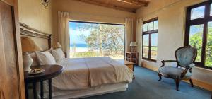 a bedroom with a bed and a table and a window at Monkey Valley Resort in Noordhoek