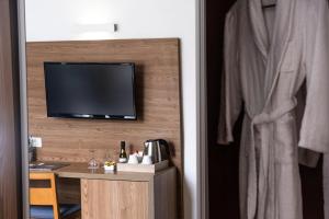 a room with a tv on a wall with a desk at Hotel Adonis Plaza in Santa Cruz de Tenerife
