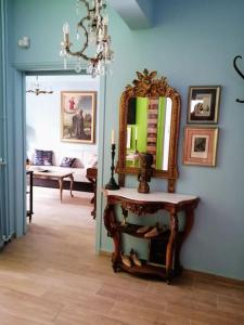 ein Wohnzimmer mit einem Spiegel und einem Tisch in der Unterkunft Angelos' Αrt Αpartment in Athen