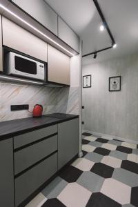 a kitchen with a microwave and a checkered floor at Квартира з неймовірним краєвидом in Kyiv