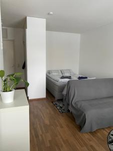 1 dormitorio con cama y pared blanca en Tilava yksiö Niinivaaralla, en Joensuu