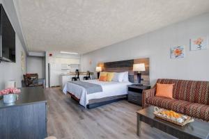 Habitación de hotel con cama y sofá en Spacious King Oceanfront Studio Suite Full Kitchen 1026, en Myrtle Beach