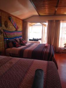 a bedroom with two beds and a window at TITICACA DELUXE LODGE in Puno