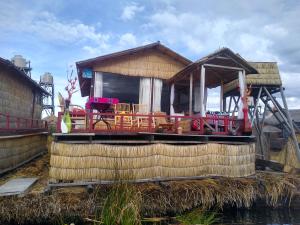 a house with a deck on the water at TITICACA DELUXE LODGE in Puno