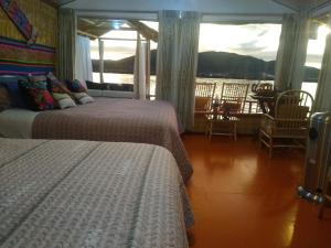 a bedroom with two beds and a view of the water at TITICACA DELUXE LODGE in Puno