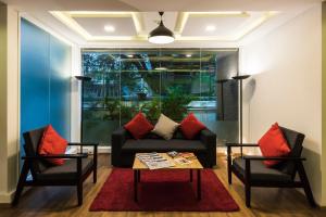 sala de estar con sofá y 2 sillas en Townhouse MG Road,Bangalore en Bangalore