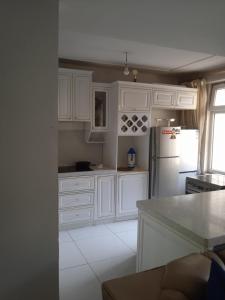a white kitchen with white cabinets and a refrigerator at Bolod Guesthouse and Tours in Ulaanbaatar