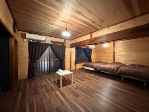 a room with two beds and a table in it at 黒まめ庵 in Tamba