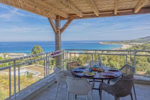einen Tisch und Stühle auf einem Balkon mit Meerblick in der Unterkunft Villa Carlisa in Algajola