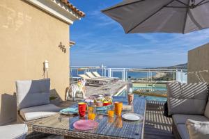 einen Tisch mit Essen und einen Regenschirm auf einer Terrasse in der Unterkunft Villa Carlisa in Algajola