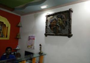 a man in a room with a painting on the wall at Hotel Amba Amravati in Amrāvati