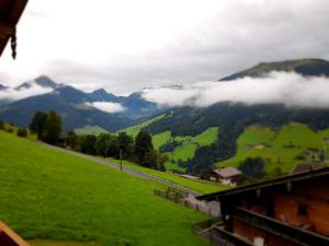 a view of a green valley with clouds in the mountains at Topp Rossmoos in Alpbach