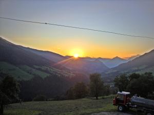 a truck parked on a hill with the sunset at Topp Rossmoos in Alpbach