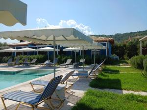 a group of chairs and umbrellas next to a swimming pool at Rock Rooms in Lefkada