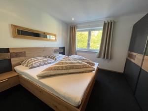 a bedroom with a wooden bed with a window at Ferienwohnung Victoria in Brixen im Thale