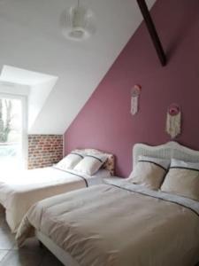 Gîte du Manoir de Camblain في Camblain-lʼAbbé: سريرين في غرفة نوم مع جدار أرجواني