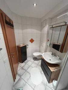 a bathroom with a sink and a toilet at Ferienwohnung Victoria in Brixen im Thale