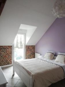 Gîte du Manoir de Camblain في Camblain-lʼAbbé: غرفة نوم بسرير كبير في العلية