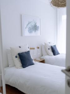 a bedroom with two beds with blue and white pillows at Chez-Marie Vue fantastique entre lac et montagne in Beckenried