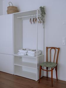 - un placard blanc avec une chaise et des serviettes dans l'établissement Chez-Marie Vue fantastique entre lac et montagne, à Beckenried