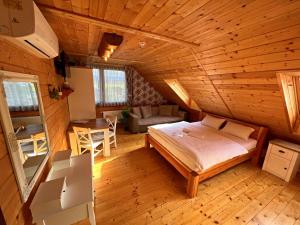 - une chambre avec un lit et une table dans l'établissement Ubytovanie v Superior izbách v podkroví Koliba Pacho, à Prievidza
