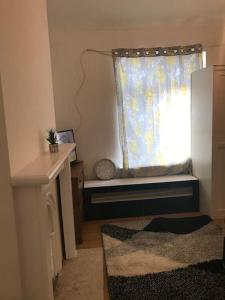 a window seat in a room with a window with a curtain at Lovely 1 bed flat in great location with garden in Ilford