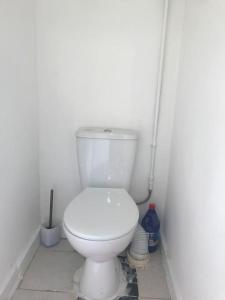 a white toilet in a corner of a bathroom at Lovely 1 bed flat in great location with garden in Ilford