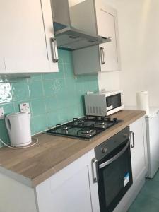 a kitchen with a stove and a counter top at Lovely 1 bed flat in great location with garden in Ilford