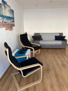 salon z 2 krzesłami i kanapą w obiekcie Nameja Best view apartamenti w mieście Jēkabpils