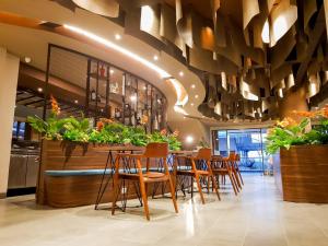 un restaurante con sillas de madera y un bar con plantas en Hotel Cianjur Cipanas, en Pasakon 1