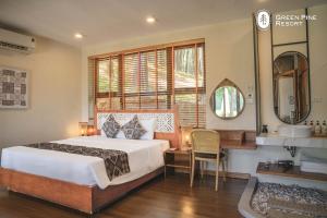 a bedroom with a bed and a desk and a window at Trang An Golf and Resort 