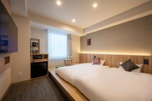 北上市SAKURA PORT HOTEL的有两张床和一扇窗户的酒店房间