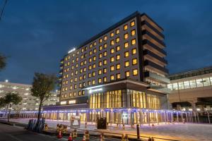 北上市SAKURA PORT HOTEL的一座前面有灯光的大楼