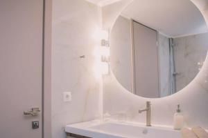 a white bathroom with a sink and a mirror at Theasis Luxury Apartment in Nafplio +21 photos