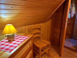 Cabaña de madera con mesa, lámpara y silla en Ubytovanie Koliba Pacho - Zrub Anicka, en Prievidza