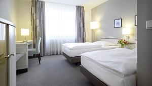 Postel nebo postele na pokoji v ubytování Sachsenpark-Hotel