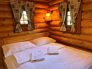 a bedroom with a bed in a log cabin at Ubytovanie Koliba Pacho - Zrub Anicka in Prievidza