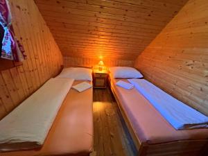A bed or beds in a room at Ubytovanie Koliba Pacho - Zrub Zuzka