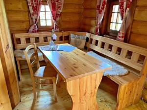 comedor con mesa de madera y sillas en Ubytovanie Koliba Pacho - Zrub Zuzka en Prievidza